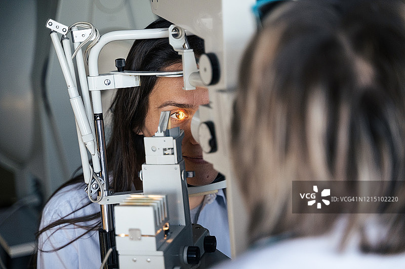 裂隙灯眼科检查。年轻女性在眼科医生处检查眼睛。白领工人。活跃的老年人在工作场所。图片素材