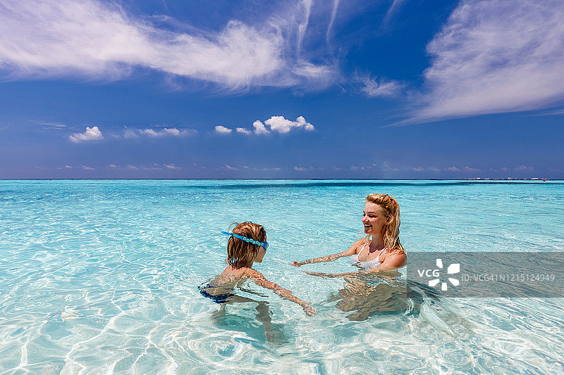 快乐的母子在夏日的海边聊天图片素材