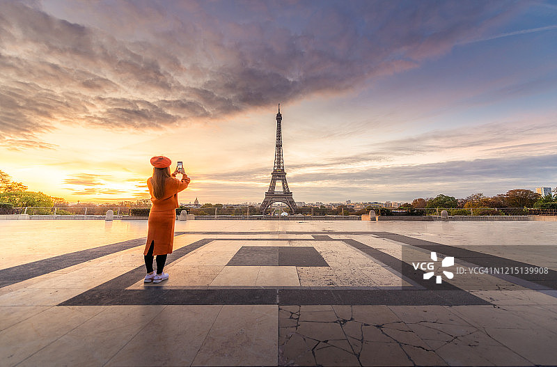 女人正在拍摄法国巴黎的埃菲尔铁塔图片素材