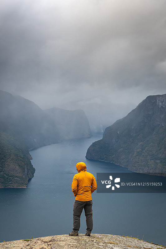 男子观看峡湾和山脉图片素材