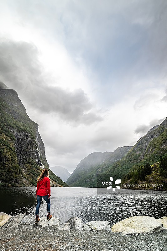 看向峡湾和山脉的女人图片素材