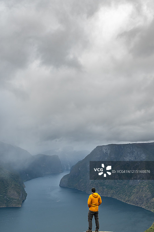 男子观看峡湾和山脉图片素材
