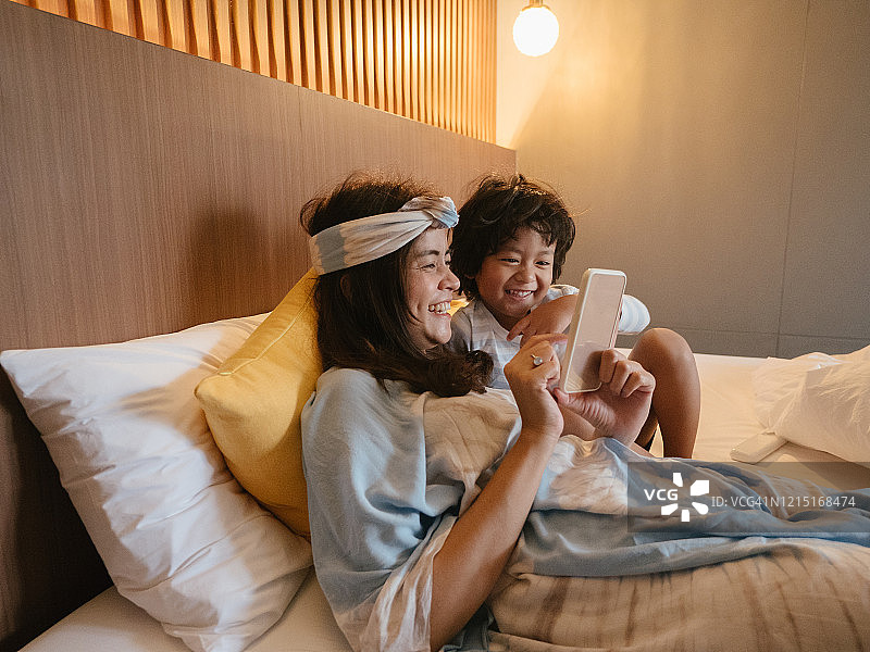 现代亚洲家庭使用智能手机的欢乐时光图片素材