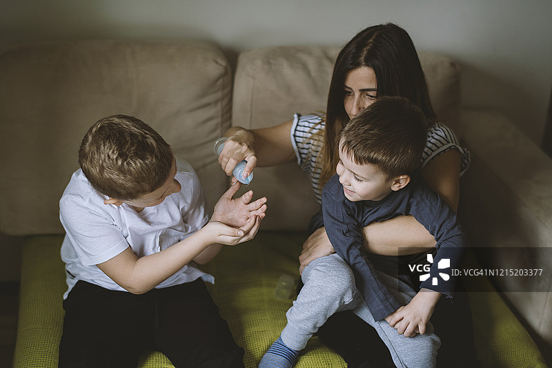 母亲教孩子们用抗菌洗手液清洁双手图片素材