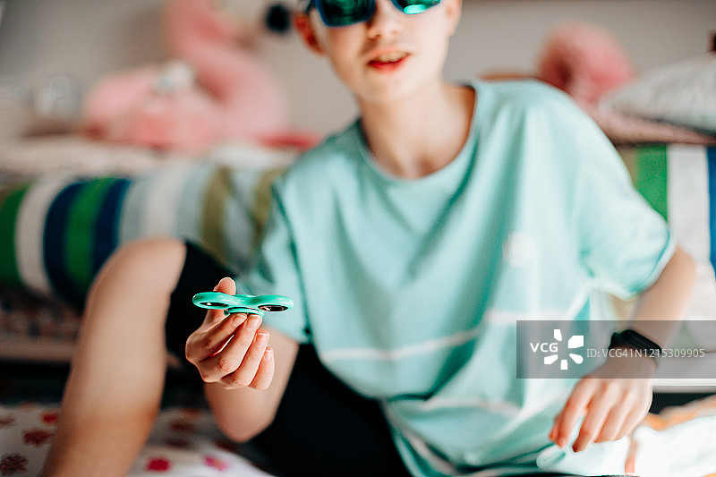 缓解压力和放松的指尖陀螺：男孩在玩指尖陀螺图片素材
