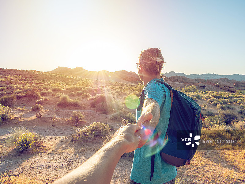 跟我来：男人牵手走向日出沙漠图片素材