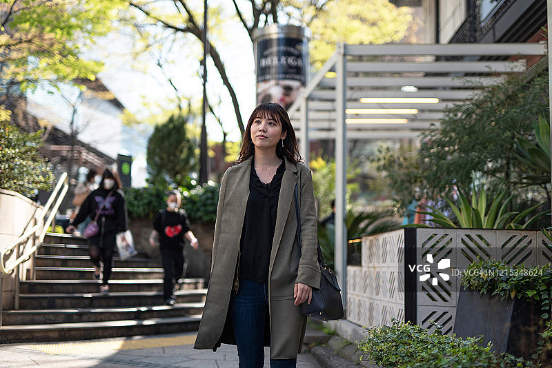 女子在东京商业区的街道上行走图片素材