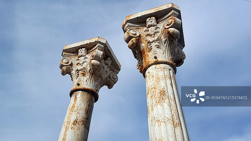 蓝色天空下的新古典主义生锈铁柱图片素材