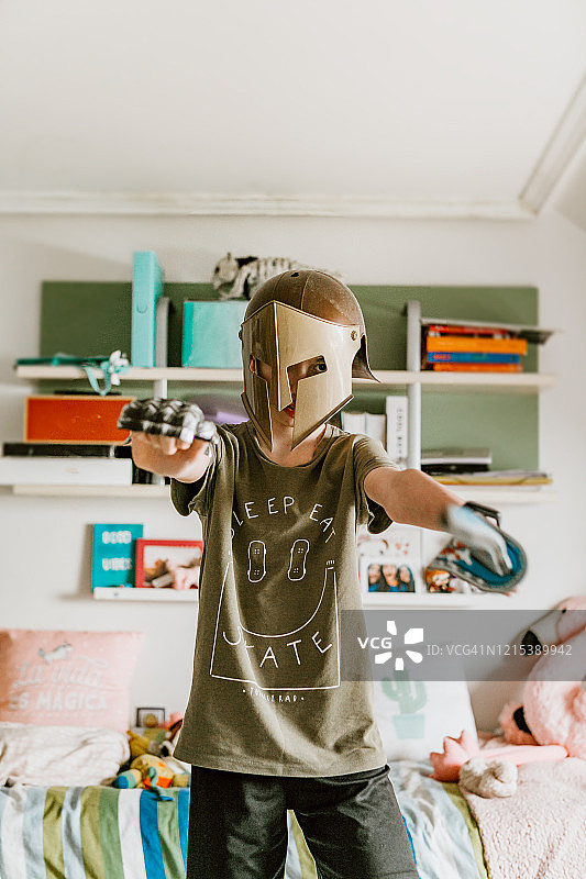 卧室里穿着战士服装的顽皮男孩图片素材
