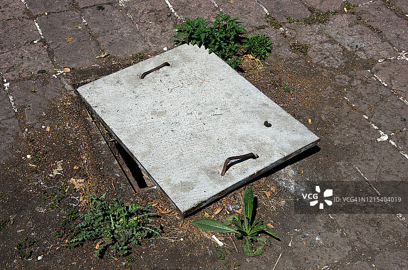 因擅自篡改而略微倾斜的混凝土沙井盖图片素材