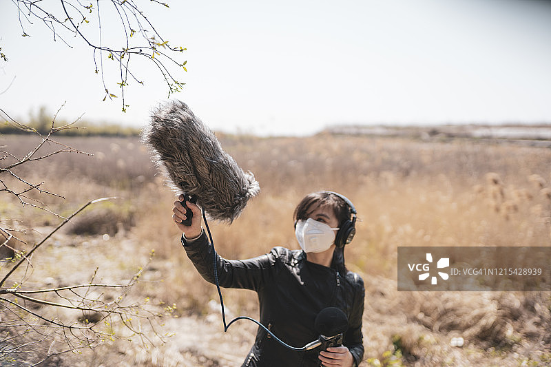 女人用枪式麦克风录制自然声音图片素材