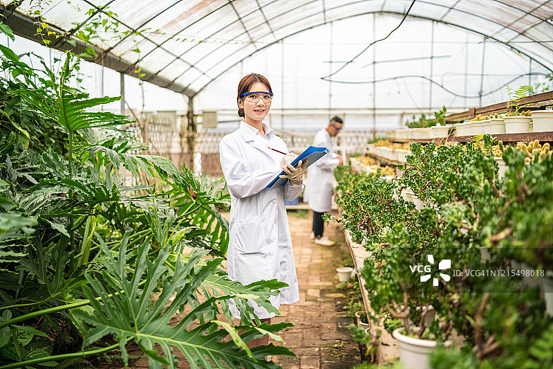 在温室工作的亚洲女科学家肖像图片素材