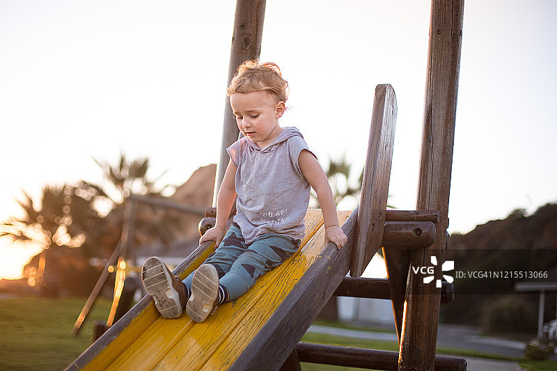 夕阳下滑滑梯的男孩图片素材