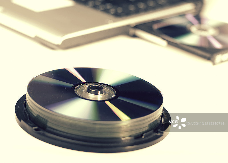 打开DVD光驱并装载DVD和一堆DVD的笔记本电脑图片素材