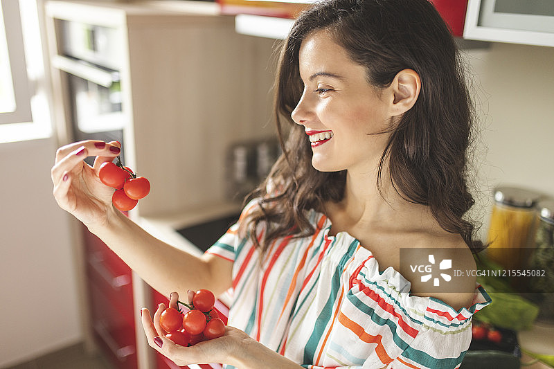 手拿樱桃番茄的女人图片素材