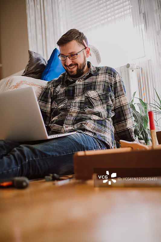 使用笔记本电脑的年轻男木匠图片素材