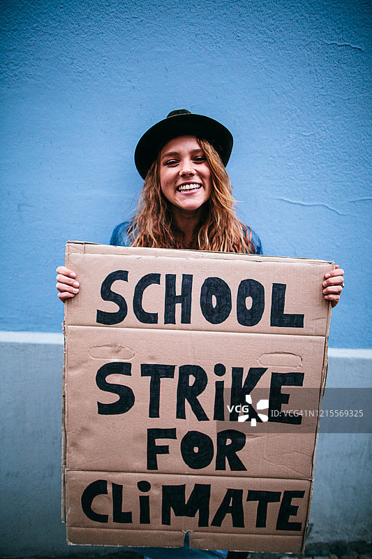 少女举着气候学校罢工抗议标志图片素材