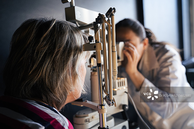裂隙灯眼科检查。年轻女性在眼科医生处检查眼睛。白领工人。活跃的老年人在工作场所。图片素材