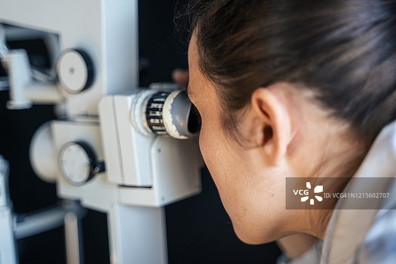 裂隙灯眼科检查。年轻女性在眼科医生处检查眼睛。白领工人。活跃的老年人在工作场所。图片素材