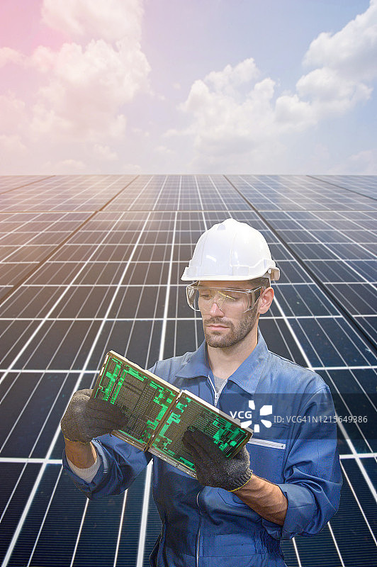 白人工程师手持电脑零件在太阳能板前图片素材