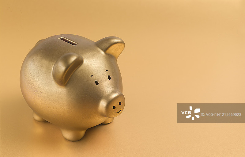 金色背景上的金色小猪储蓄罐图片素材