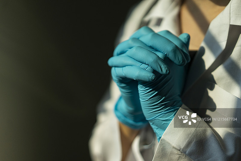 戴着防护面罩和个人防护装备的亚洲女医生祈祷停止新冠疫情图片素材