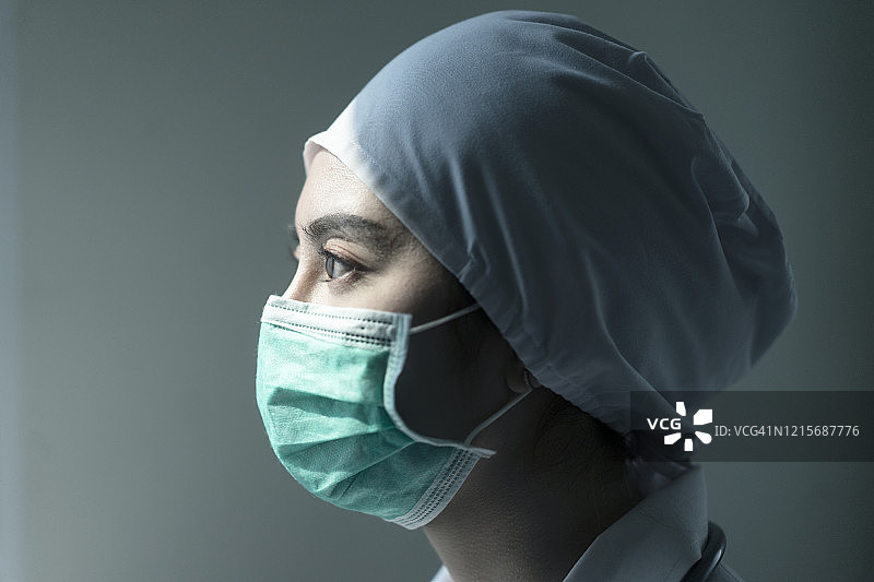 戴着防护面罩和PPE套装，手持注射器的亚洲女医生肖像，关于新冠病毒爆发或Covid-19隔离概念图片素材