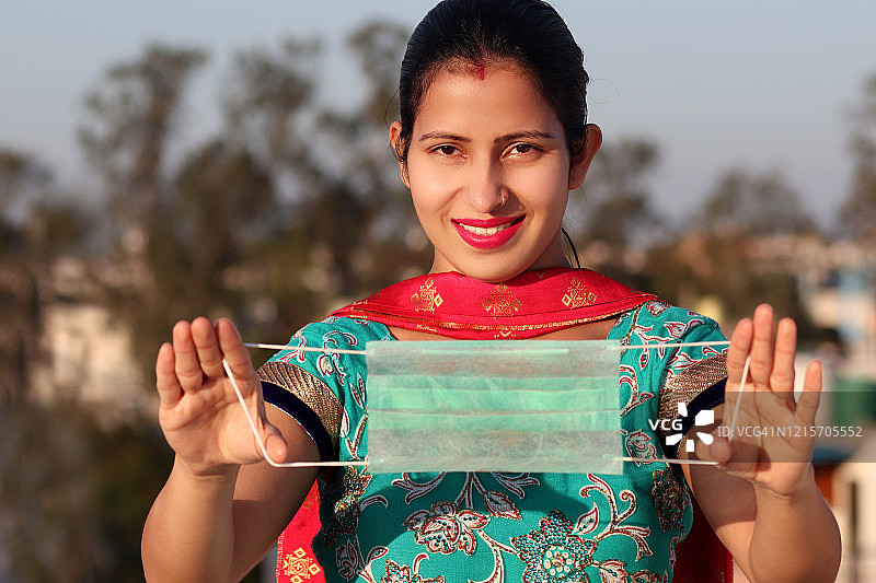 手持COVID-19防护口罩的女人图片素材