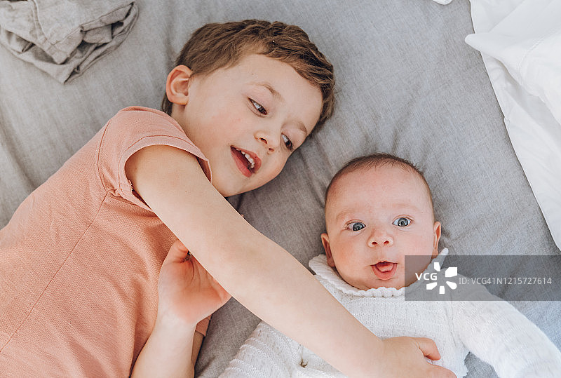 兄弟在床上和婴儿玩耍图片素材