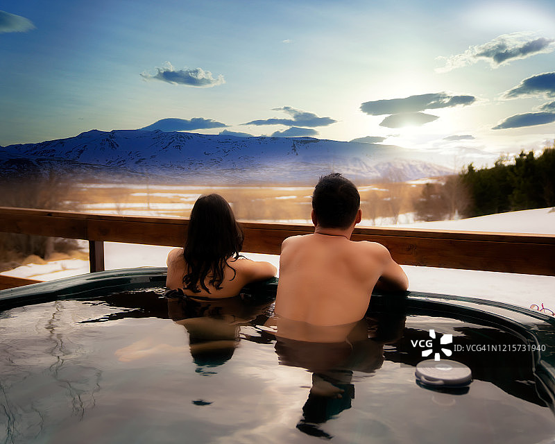 在冰岛豪华别墅享受温泉的亚洲情侣图片素材