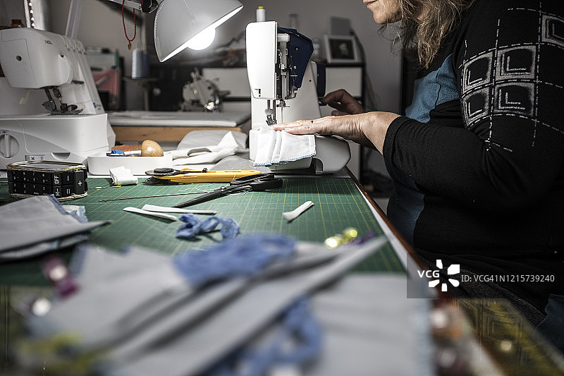 中年妇女在家缝制防护口罩侧视图图片素材