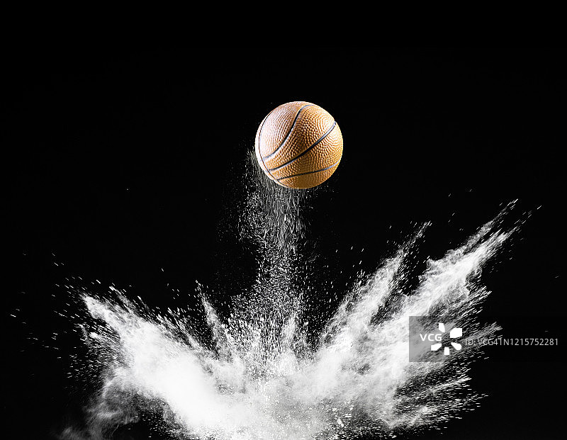 篮球在黑色背景的土地和粉末表面上的撞击和反弹图片素材