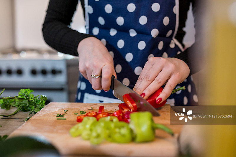 年轻女人在厨房炉灶旁做饭图片素材