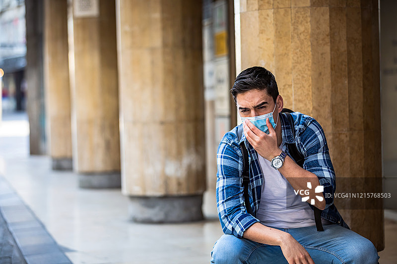 生病的男人戴着防护口罩，以预防公共场所的传染病、流感或冠状病毒。图片素材