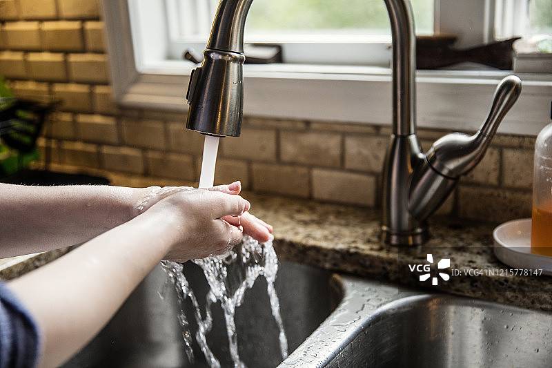 少女在厨房洗手的特写图片素材