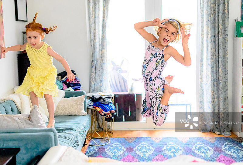 小女孩在凌乱的客厅里跳跃玩耍图片素材