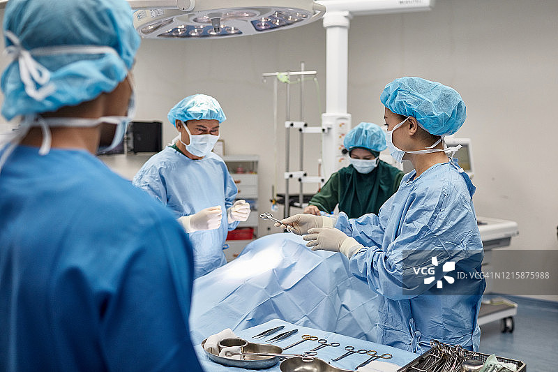 手术过程中，外科技术人员将器械递给医生图片素材