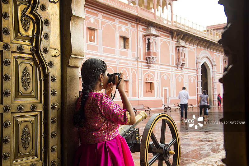 女游客在印度斋浦尔城市宫殿拍照图片素材