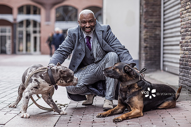 老城区里带着狗的黑人复古黑帮男子肖像图片素材