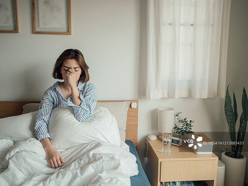 在家卧床喝水的患流感亚洲女人图片素材