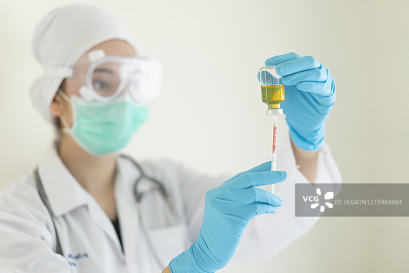 穿防护服戴口罩的医生手持血清试管图片素材
