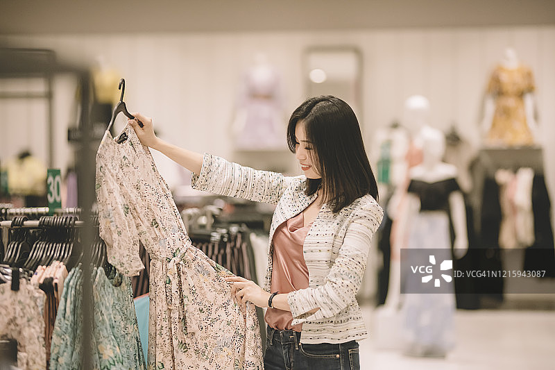在服装店购物和试穿新衣服的亚洲女性图片素材