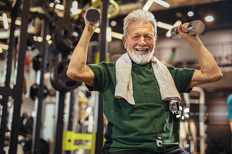在健身房用哑铃锻炼的老年男人图片素材
