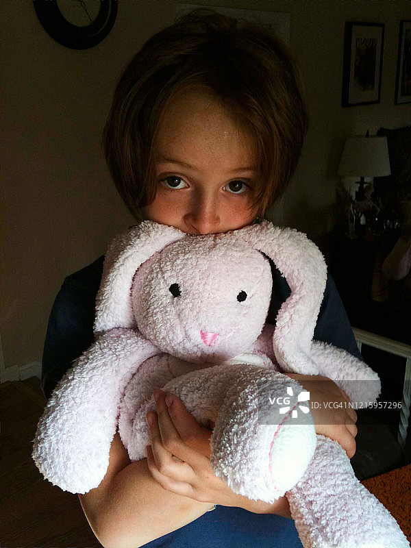 抱着毛绒玩具的红发女孩特写图片素材