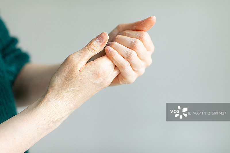 女士涂抹护手霜以缓解消毒液引起的皮肤干燥图片素材