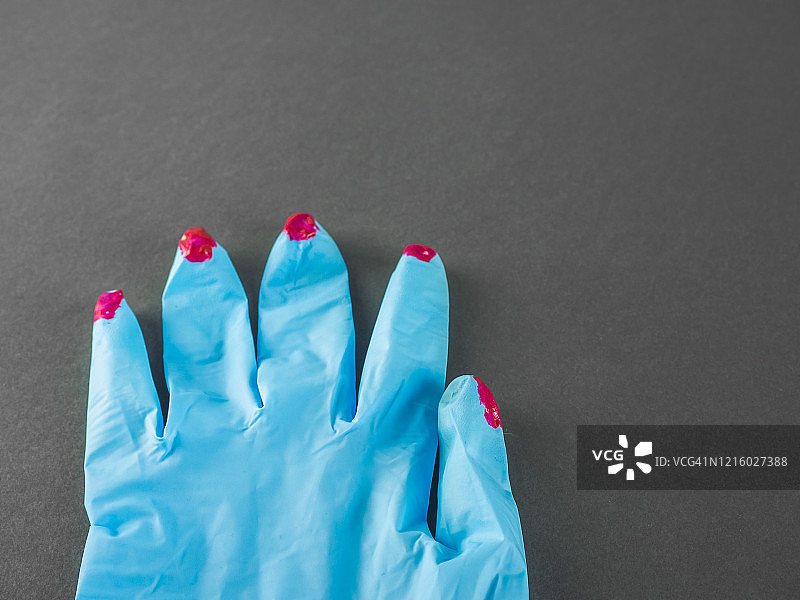 涂有红色指甲油的防护丁腈手套图片素材