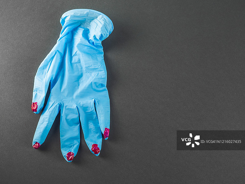 涂有红色指甲油的防护丁腈手套图片素材