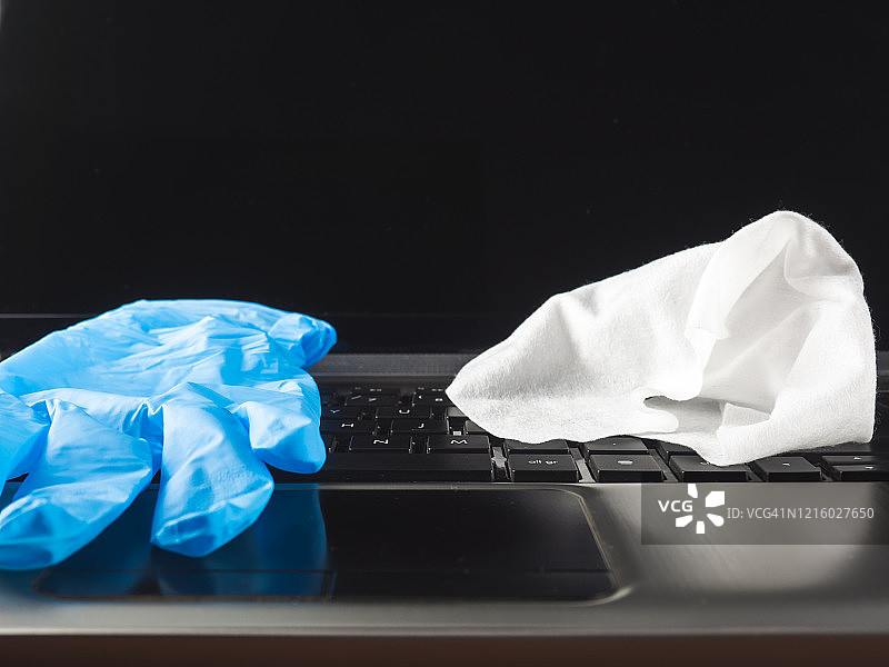 丁腈手套和笔记本电脑键盘上的布图片素材