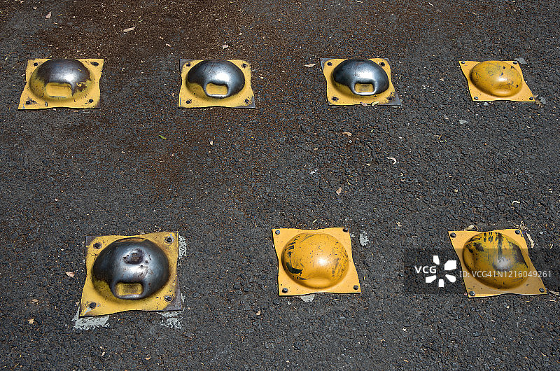 沥青路面上磨损的金属减速带图片素材
