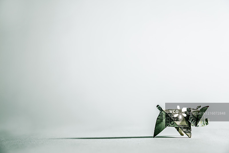 用20美元制作的折纸猪，灰色背景带阴影图片素材